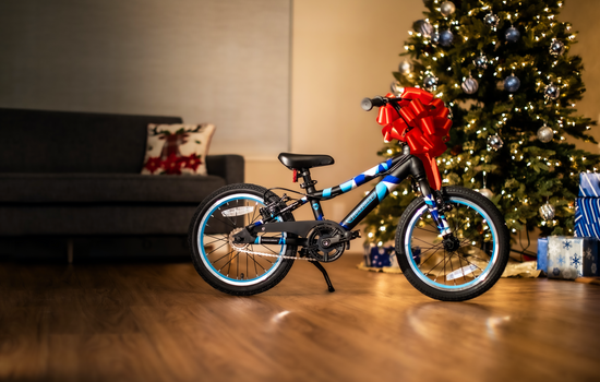 Guardian 16" Ethos Bike in front of a Christmas tree with a large red bow